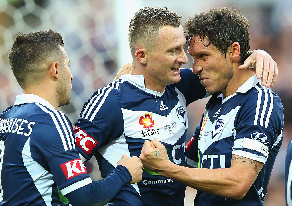 Milligan celebrates with Besart Berisha, Kosta Barbarouses as Victory went on their way to the title
