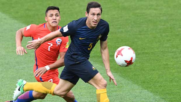 Mark Milligan gets to the ball ahead of Chile's Alexis Sanchez.