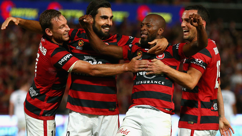 Wanderers players celebrate one of Romeo Castelen's three goals against the Roar.