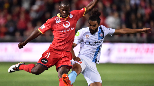 Reds striker Bruce Djite fires a shot on goal in front of City midfielder Osama Malik.