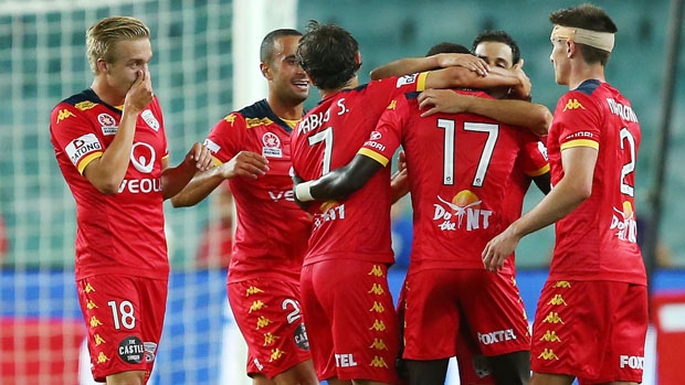 Adelaide United players celebrate a goal in their 3-0 win over Sydney FC.