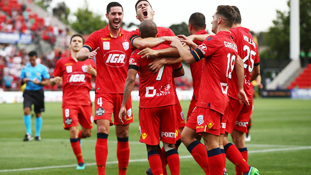 Adelaide United celebrate one of Henrique's two goals in their win over Wellington Phoenix.
