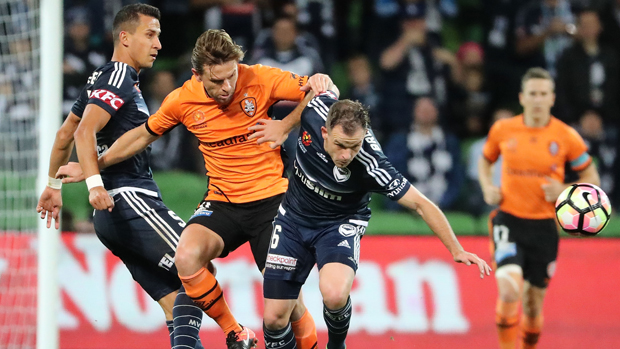 Brisbane Roar's Brett Holman and Victory's Leigh Broxham tussle for the ball at AAMI Park.