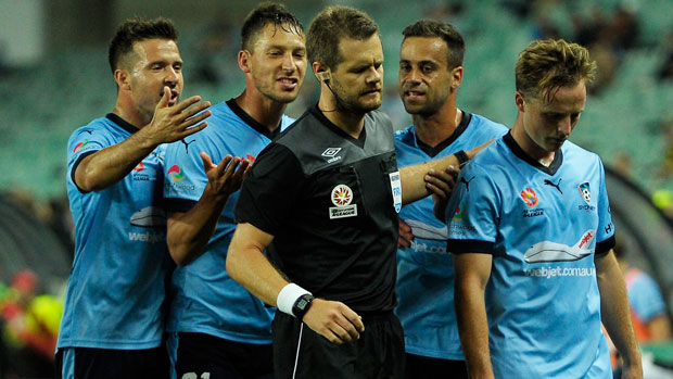 Sydney FC players surround referee Chris Beath.