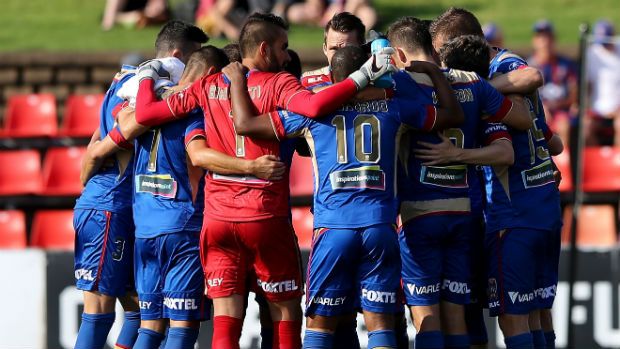 The Newcastle Jets form a huddle before kick-off at Hunter Stadium.